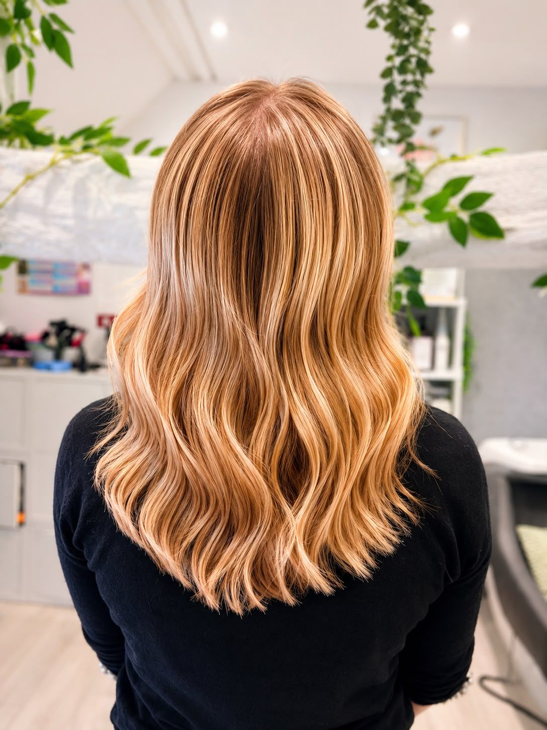 Back view of shoulder-length golden copper-blonde hair with soft waves and warm highlights
