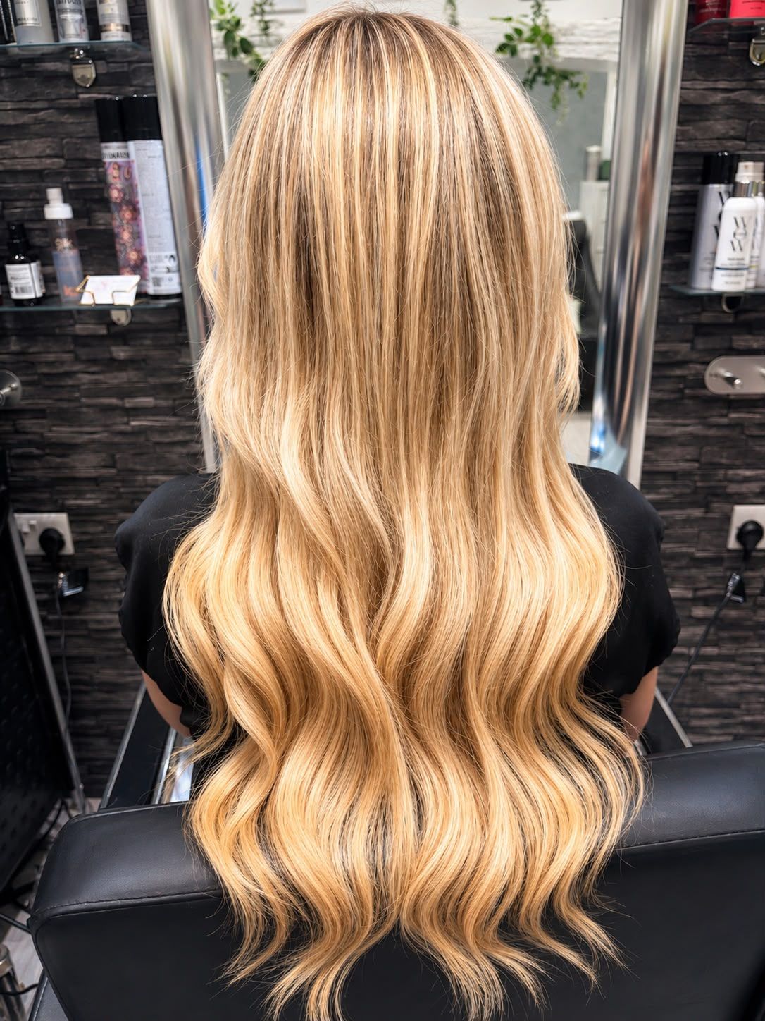 Back view of long golden blonde hair with soft waves and blended highlights